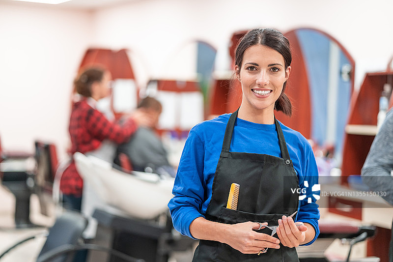 女理发师站在美发工作室里图片素材