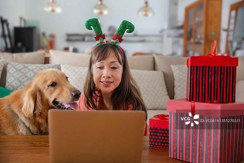 亚洲女人通过电话会议展示圣诞礼物图片素材