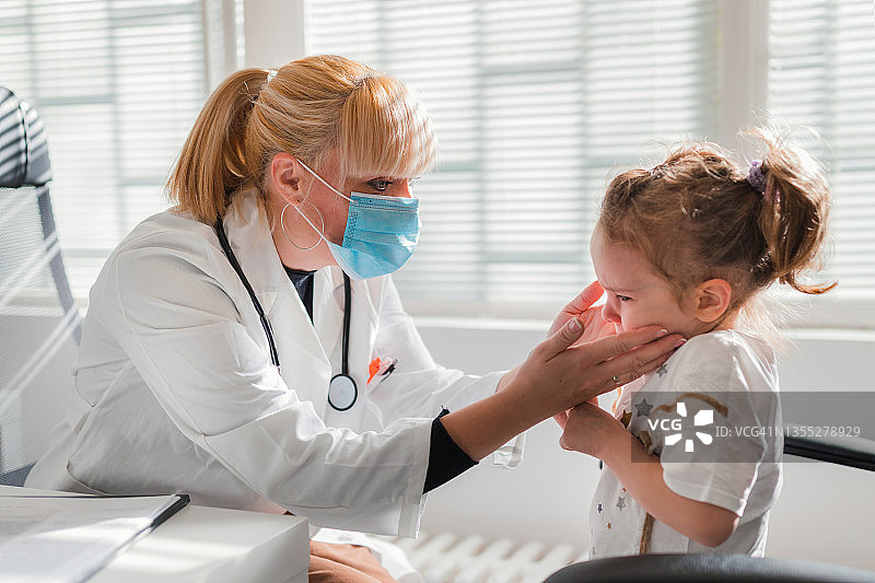 女医生检查小孩的扁桃体和喉咙图片素材