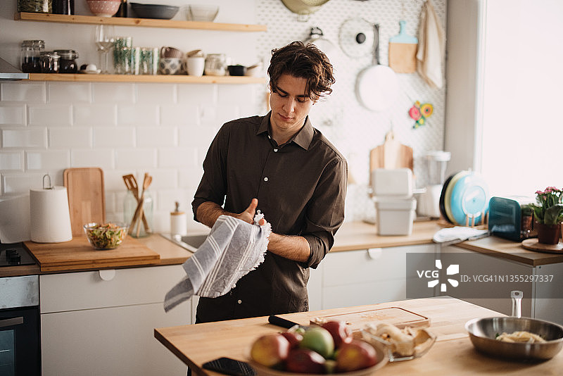 男人用厨房用纸擦手图片素材