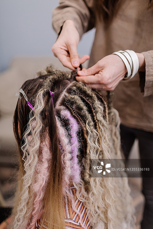 年轻欧洲女孩在家编辫子图片素材