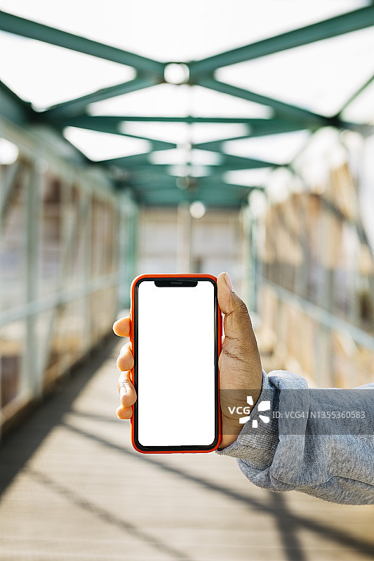 在桥上手持智能手机图片素材