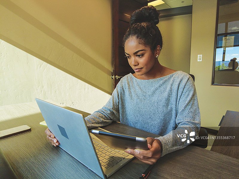 在办公室使用笔记本电脑研究Z世代的非裔美国女性图片素材
