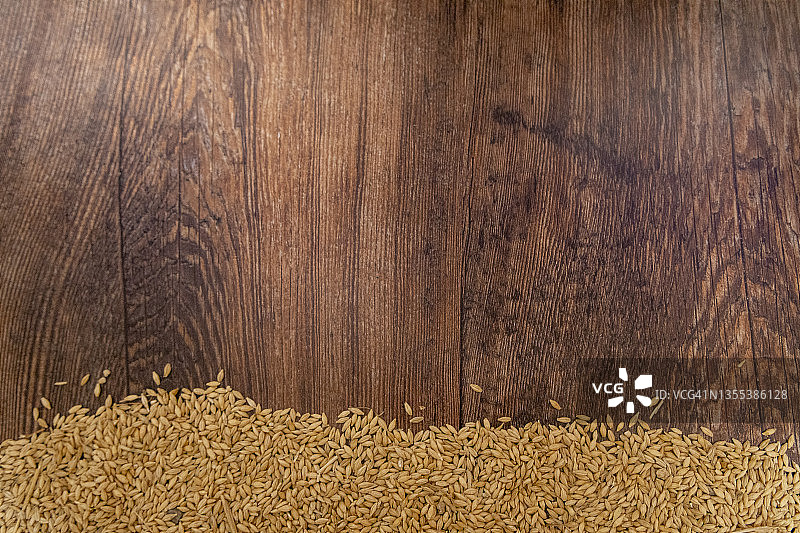 木质背景上的大麦粒 - 米色和棕色图片素材