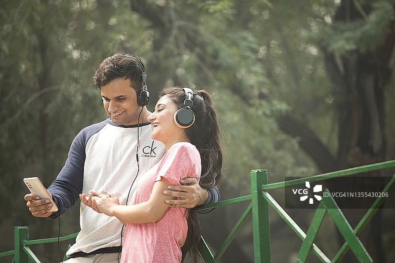 情侣在公园听音乐图片素材