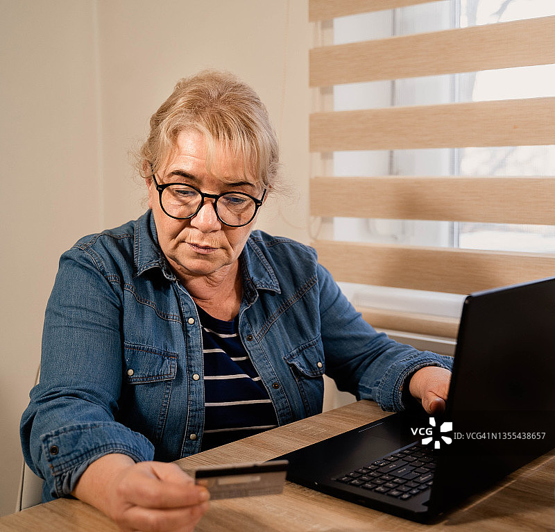 老年妇女使用信用卡进行在线购物图片素材