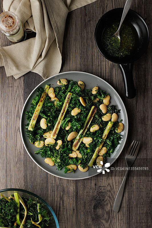 健康纯素羽衣甘蓝、烤韭葱和白豆沙拉图片素材