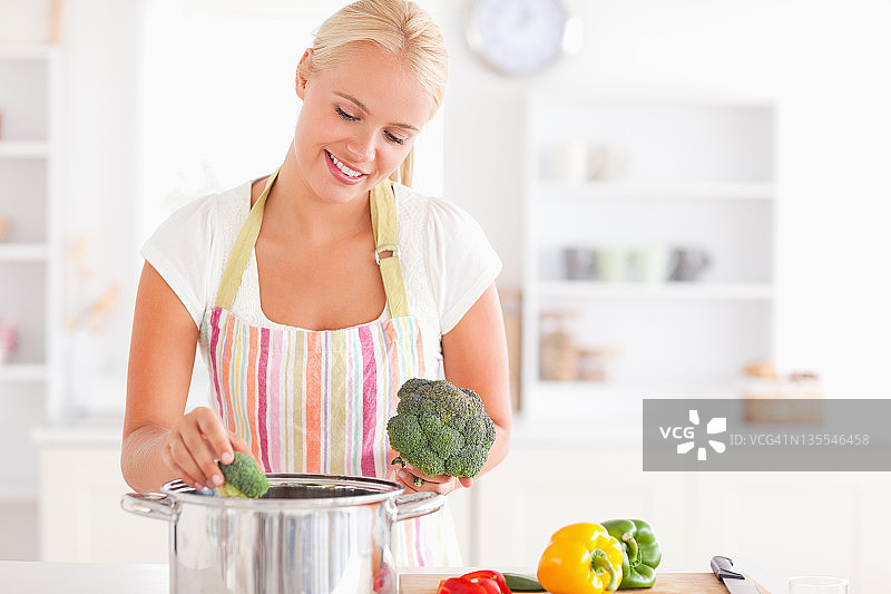 女人把卷心菜放入沸水中图片素材