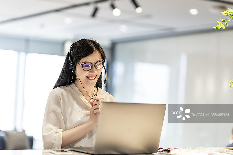 自信的亚洲女商人与她的商业伙伴进行视频会议图片素材