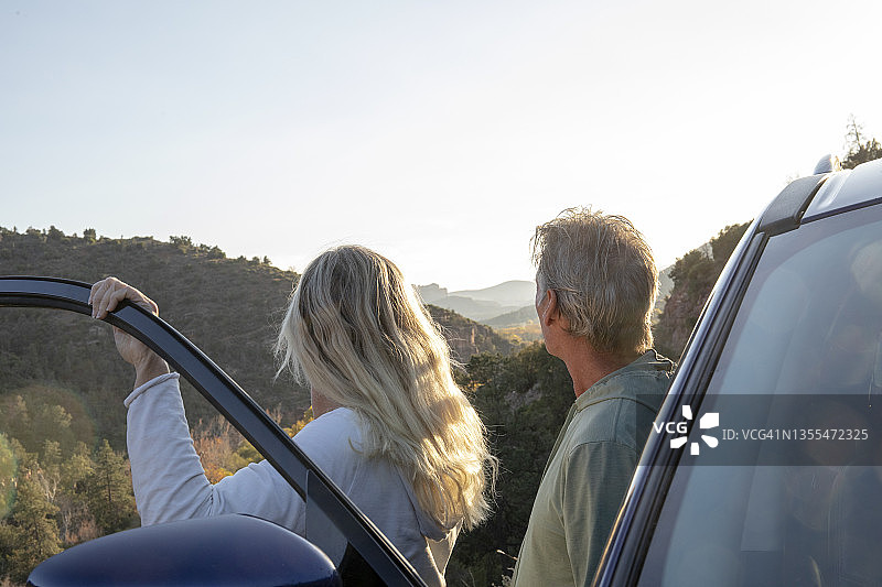 一对中年夫妇在乡村道路旁停放的汽车外放松图片素材