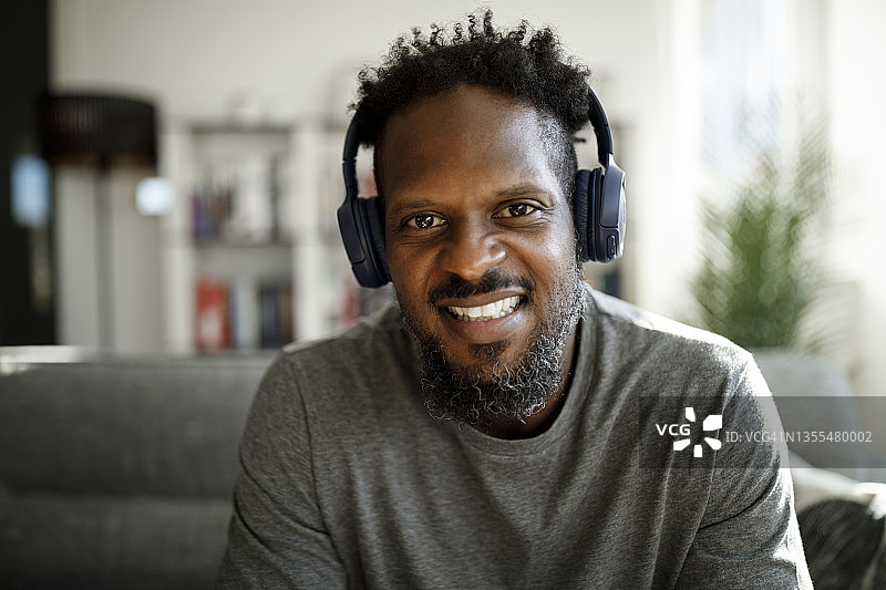 戴着耳机的微笑男人在家打视频电话图片素材