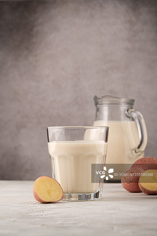 玻璃杯和水罐中的马铃薯植物奶非乳制饮品。健康的素食和纯素饮品概念，有复制空间图片素材