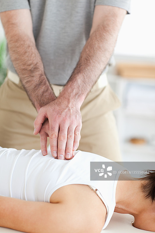 按摩师正在为女人按摩背部图片素材