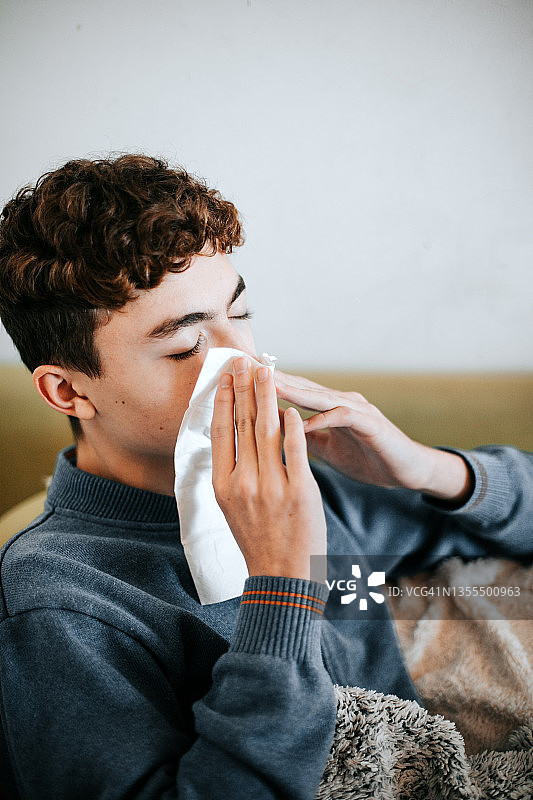 患流感的男孩正在擤鼻涕图片素材