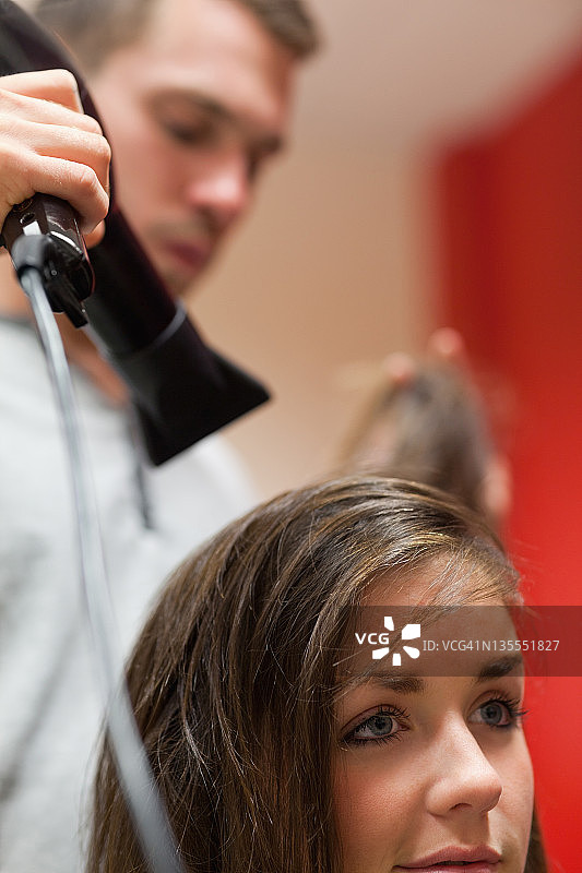 正在吹头发的英俊发型师肖像图片素材