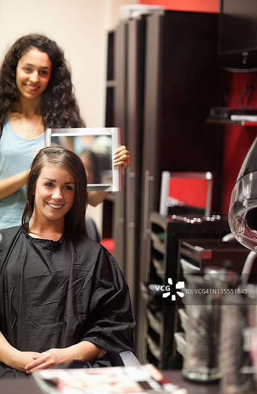 发型师向顾客展示新发型肖像图片素材