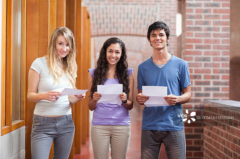 微笑的学生拿着一张纸图片素材