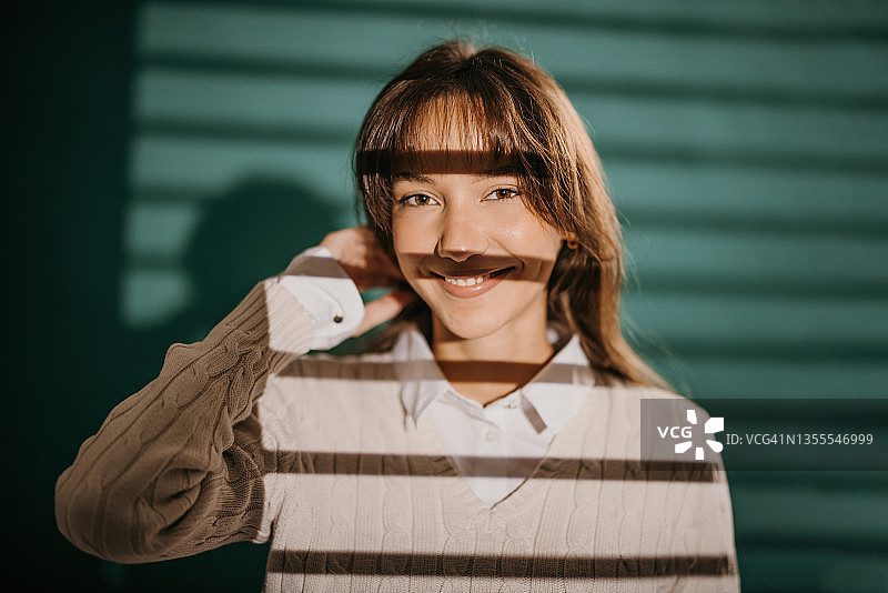 站在绿色背景前的微笑美丽女人图片素材