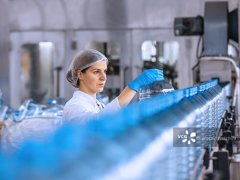 瓶装工厂的技术人员在装运前检查水瓶。图片素材