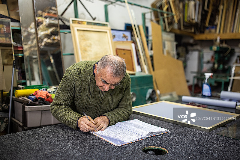 在工作室整理日程的敬业老年男性图片素材