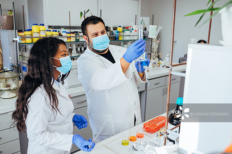 两位科学家在现代实验室里用移液管图片素材
