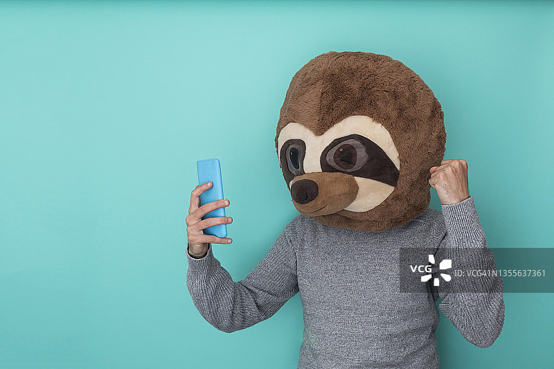 戴动物头套用手机的快乐男人图片素材