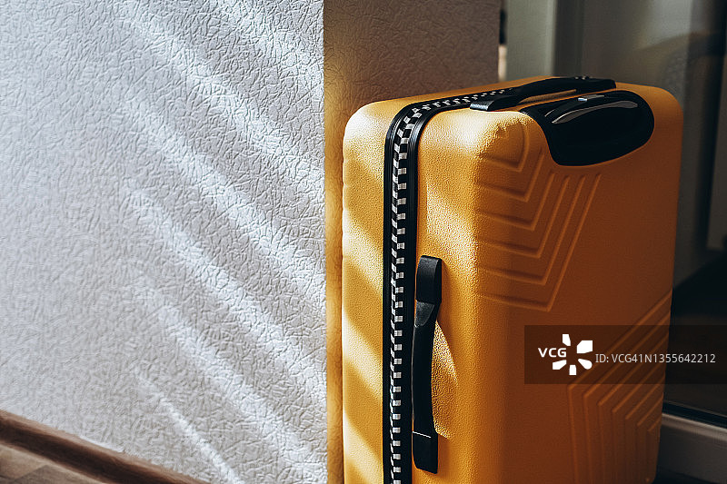白色墙壁旁的黄色行李箱图片素材
