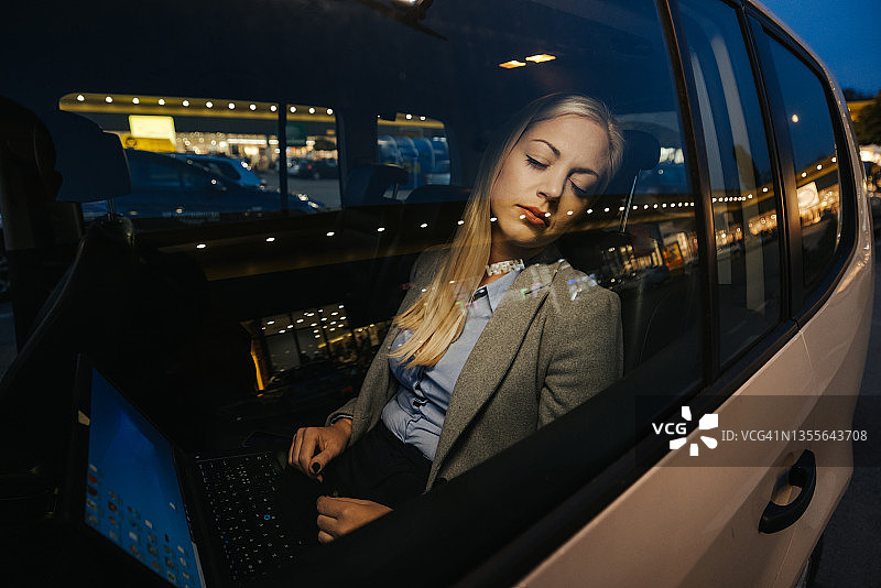 疲惫的女商人在出租车里睡觉图片素材