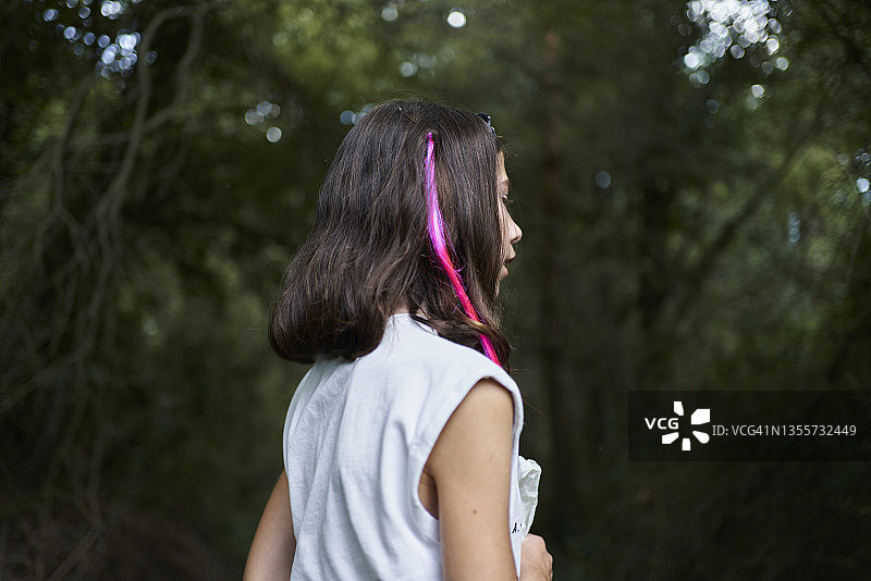 深色头发粉色挑染的女孩户外散步侧视图图片素材