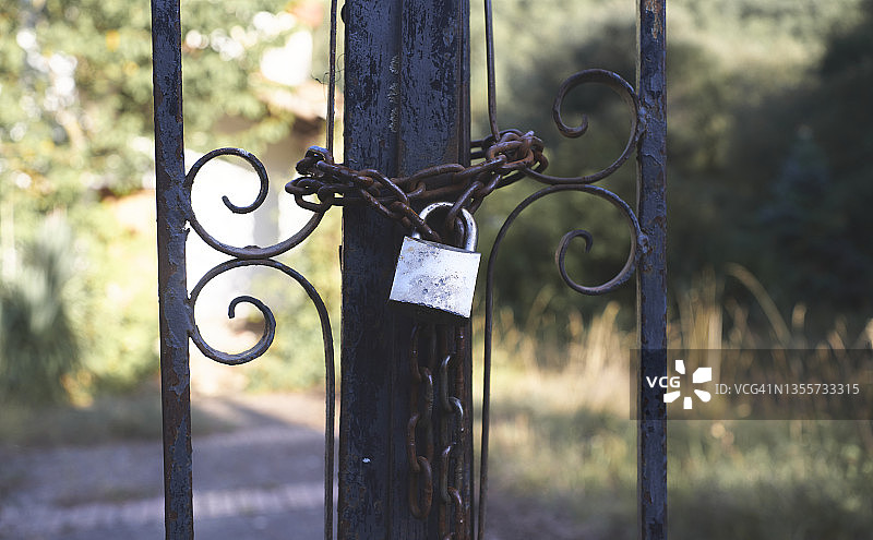 带锁链和挂锁的旧生锈铁栅栏特写图片素材