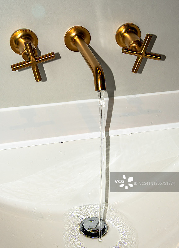 金色不锈钢水龙头流出的冷热水图片素材