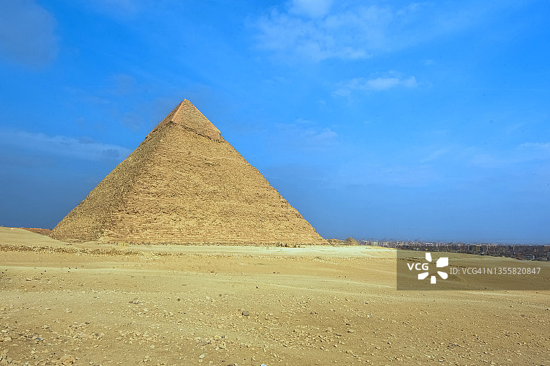 埃及吉萨的卡夫拉金字塔（又名切夫伦金字塔），背景是开罗天际线和大量的沙漠图片素材