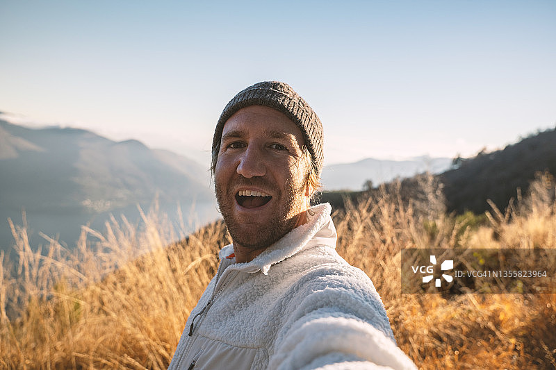 快乐的年轻人在山顶自拍图片素材