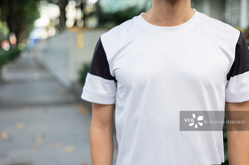 在卷帘门前跑步和跳跃的亚洲中年运动男人。健康和健身概念。图片素材