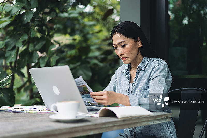 专注的亚洲女性在花园里远程办公图片素材