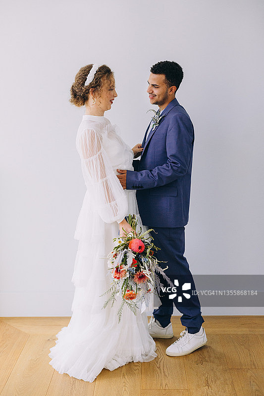 婚礼仪式前拥抱的新娘和新郎，新娘手捧花束图片素材