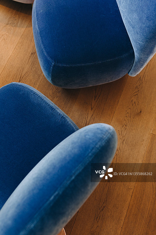 木地板上的蓝色丝绒扶手椅细节图片素材