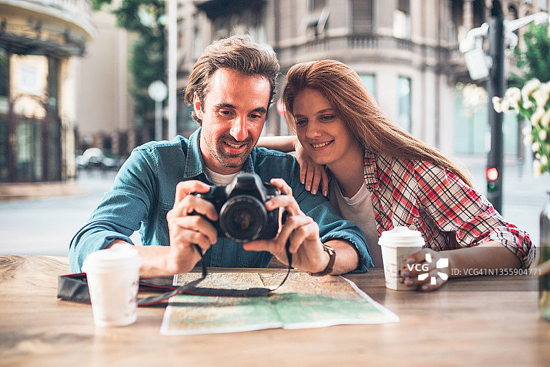 旅途中喝咖啡看照片的幸福情侣图片素材