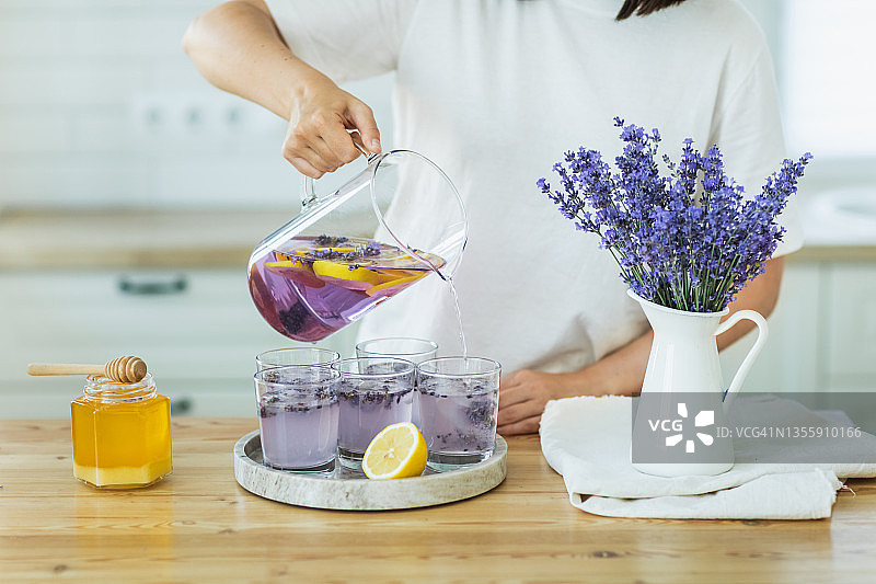 厨房桌子上的蜂蜜、冰块、柠檬汁和薰衣草鸡尾酒图片素材