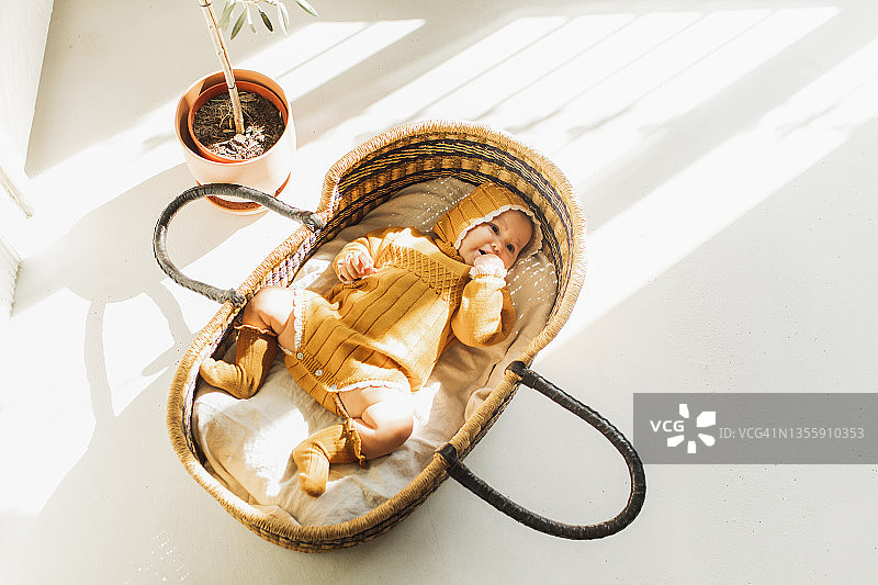 可爱的小宝宝在柳条篮子里醒来图片素材