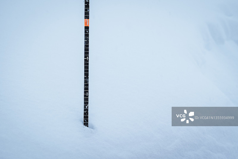 插入深雪中的带有深度标记的雪崩探针图片素材