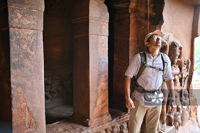 男人在印度卡纳塔克邦巴达米看着一座古老的印度教石庙中的石雕图片素材