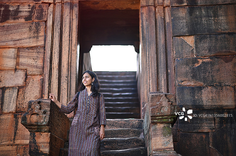 站在印度教石窟神庙入口台阶上的女人，卡纳塔克邦巴达米图片素材