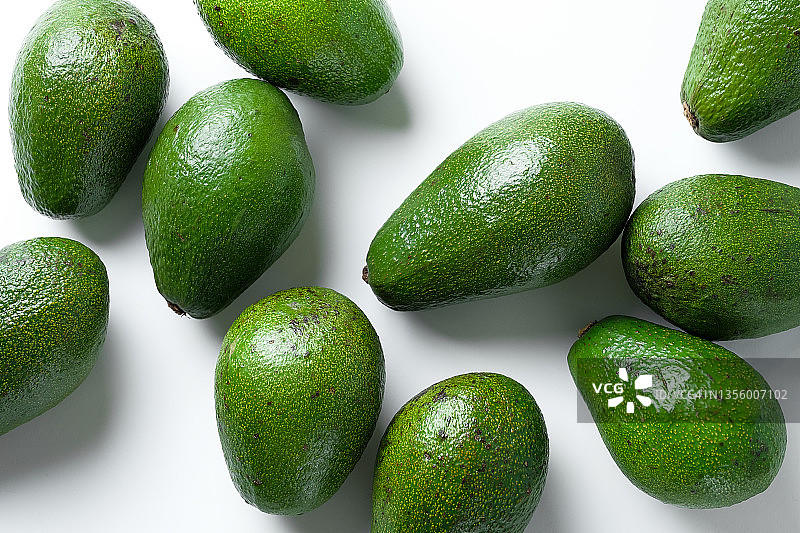 白色背景下的绿色成熟鳄梨，素食主义和生食理念图片素材