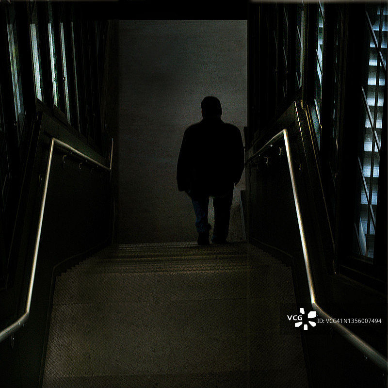 男人站在火车楼梯底部的阴影里图片素材