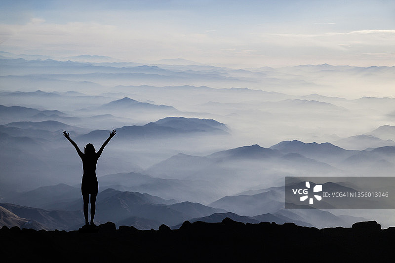 山丘日落时分的女人剪影图片素材