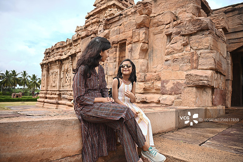 母女坐在古印度石制寺庙外图片素材