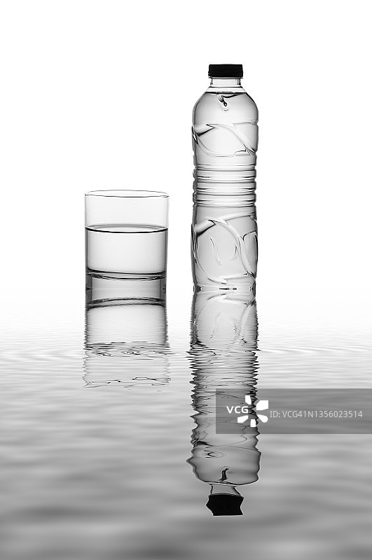 白色背景下的塑料水瓶在水面上的倒影图片素材