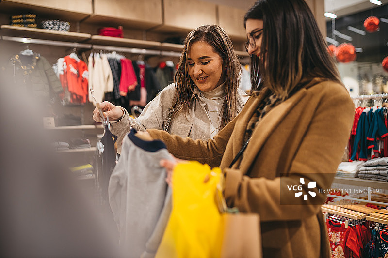 年轻女子在购物中心挑选衣柜图片素材