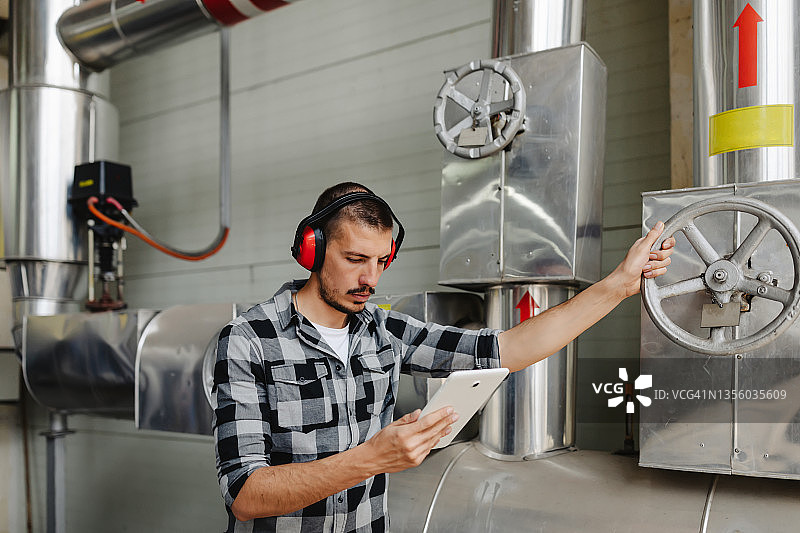技术员检查房屋供暖系统压力表图片素材
